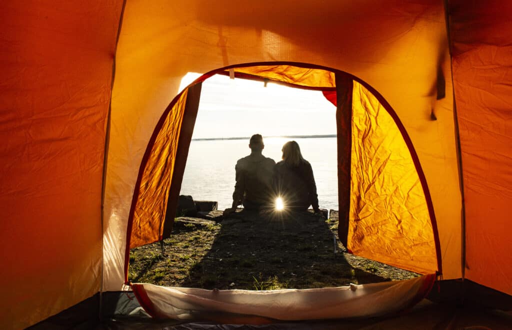 Couple sitting by their tent. Explore Ontario and the Frontenac Arch Biosphere.