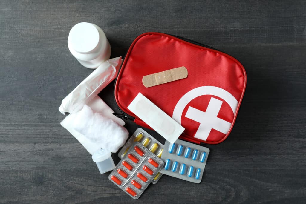 First aid medical kit on dark wooden background